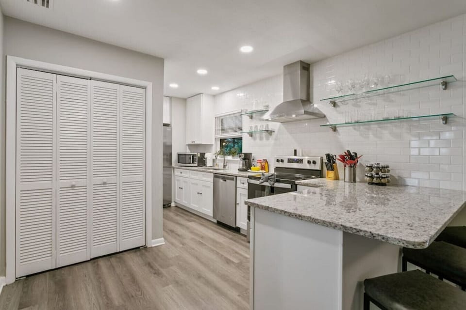Kitchen features bar area, oven, stove, dishwasher, microwave, large cabinet space, and all amenities.