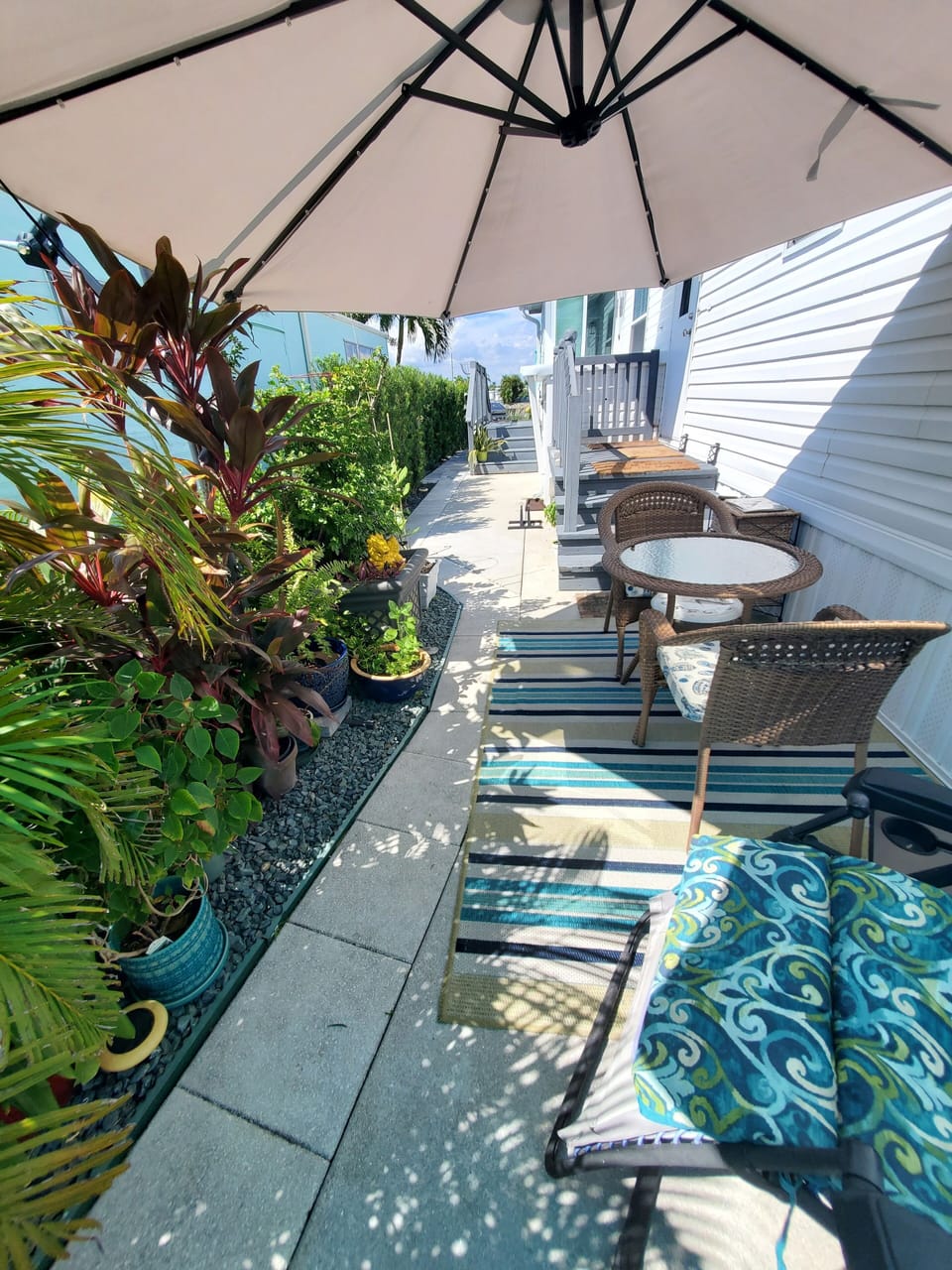 Entry.  Lush garden sitting area. BBQ  grill to the left.