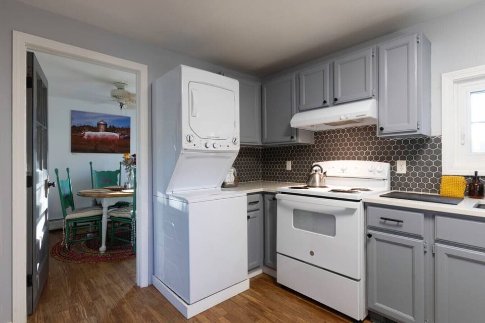 Newly remodeled kitchen in soft gray tones with granite countertops, sink, refrigerator, stove, and microwave. Fully stocked with dishware, toaster, coffee maker, coffee, salt, pepper, olive oil, plus a washer and dryer for convenience. 🍳☕🧺