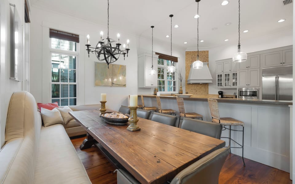 Gather around this rustic dining table while your chef creates magic in the open kitchen. Natural light streams through tall windows.