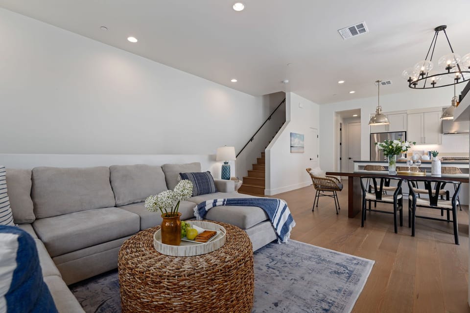 Corner view of the open living area, living room flows seamlessly into the dining room and kitchen