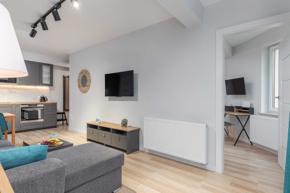 A wide view of the open living space featuring a dining table, sofa, and a cozy atmosphere.
