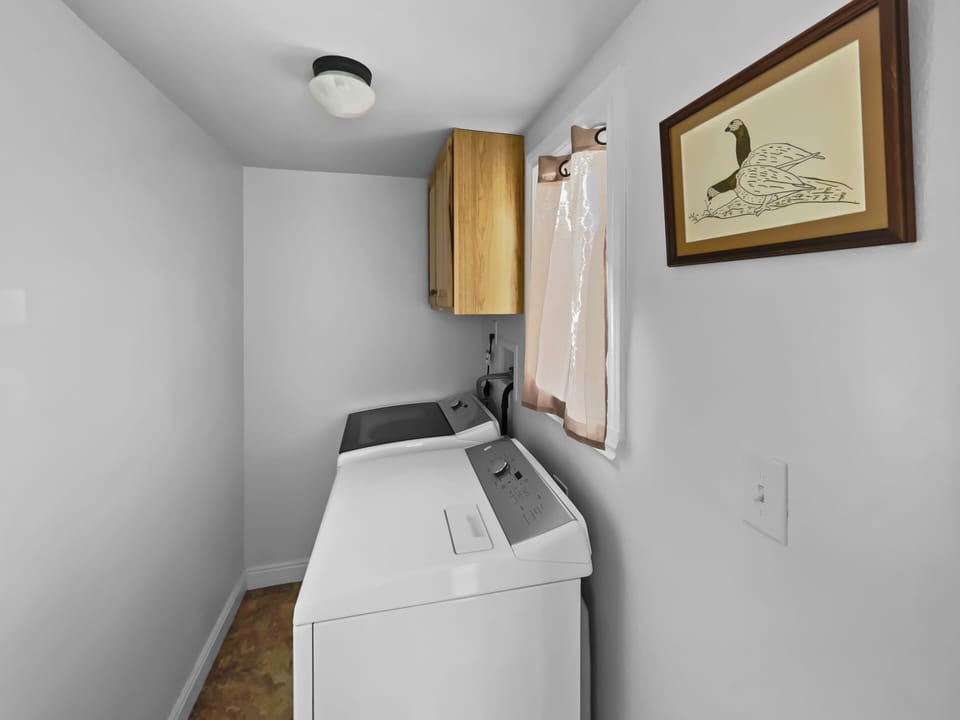 Laundry area with full washer and dryer with detergent for guest use.