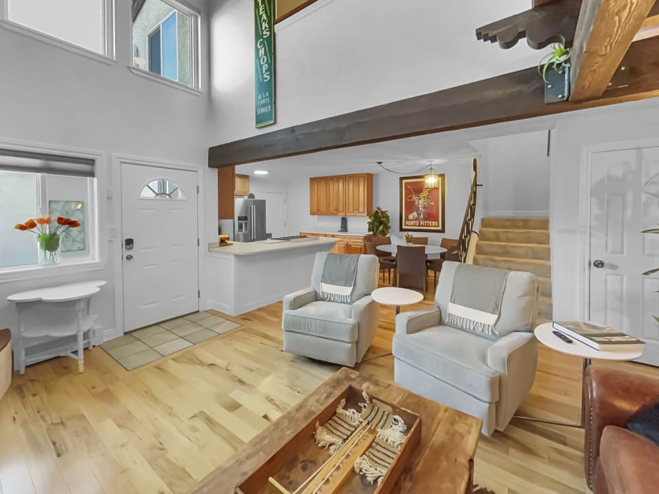 A cozy living space with two armchairs and a view into the kitchen area.