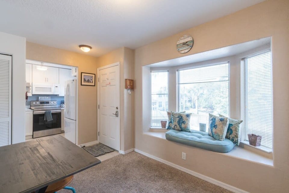 Cozy bay window seating area with natural light next to a modern kitchen.