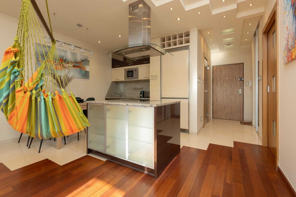 A hanging hammock chair in vibrant striped fabric, adding a playful element to the room.
