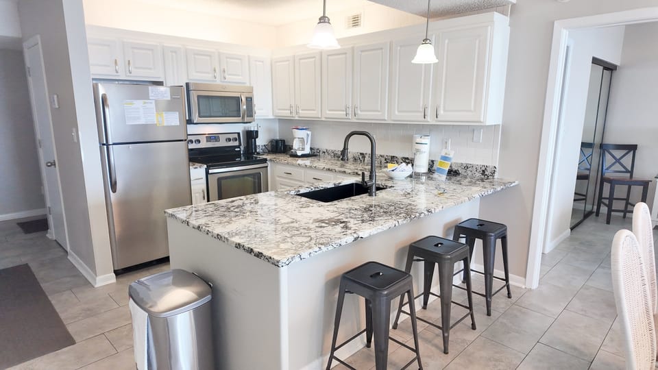 The expansive kitchen counter/bar provides additional seating for 3 adjacent to the dining room so everyone can enjoy eating together.