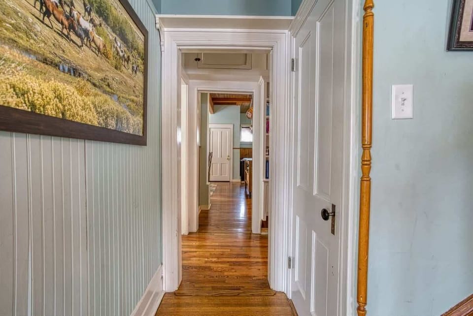 【Upstairs Hallway】Wood-paneled corridor connecting the bedroom wing — original 1896 trim.