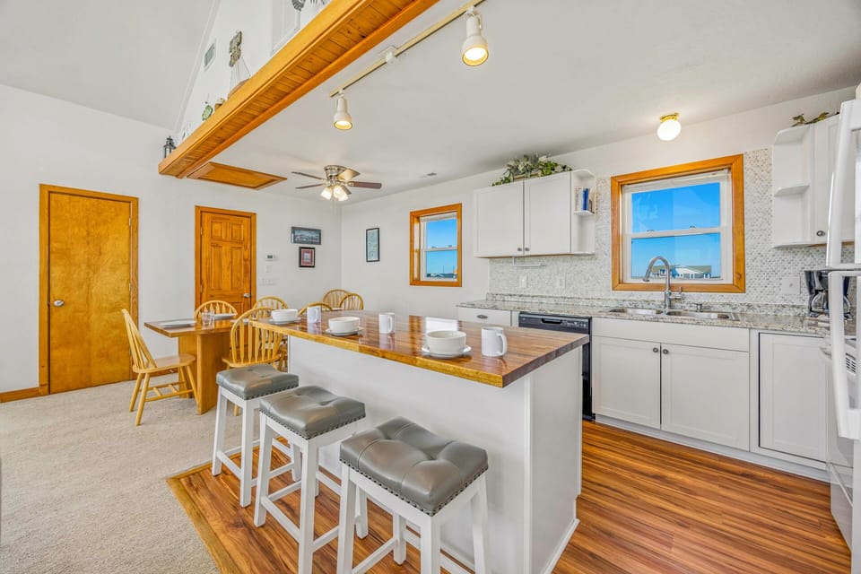 Cook together in this bright open kitchen featuring granite counters, modern appliances, and cozy bar seating for casual dining.