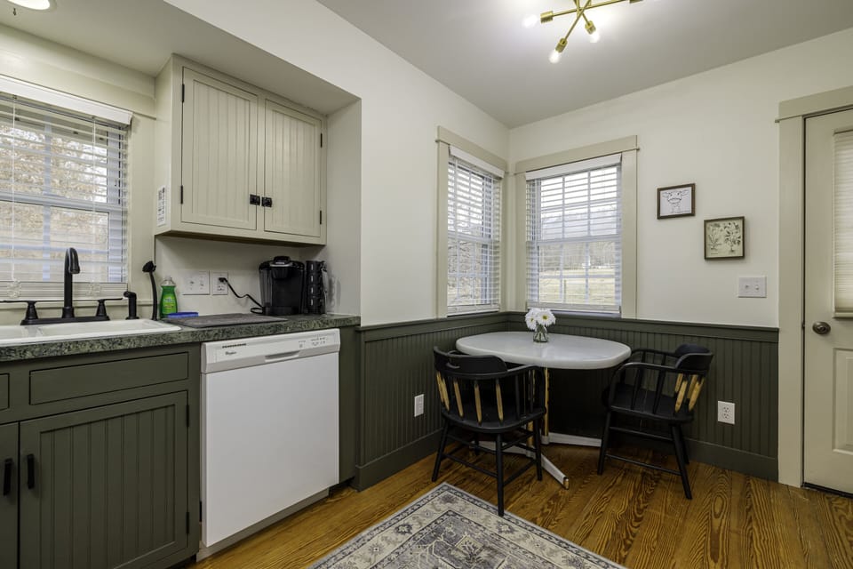 Quaint kitchen with dishes, pots and pans & other utensils.