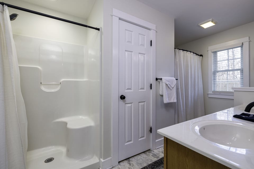 Master bathroom has a double sink vanity, a standup shower and a bathtub/shower.