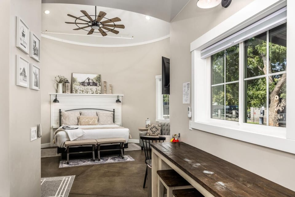 Open-concept space featuring beautiful farmhouse décor and a cozy king bed