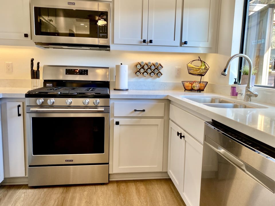 Full kitchen with stove, oven, microwave, and full size refrigerator.