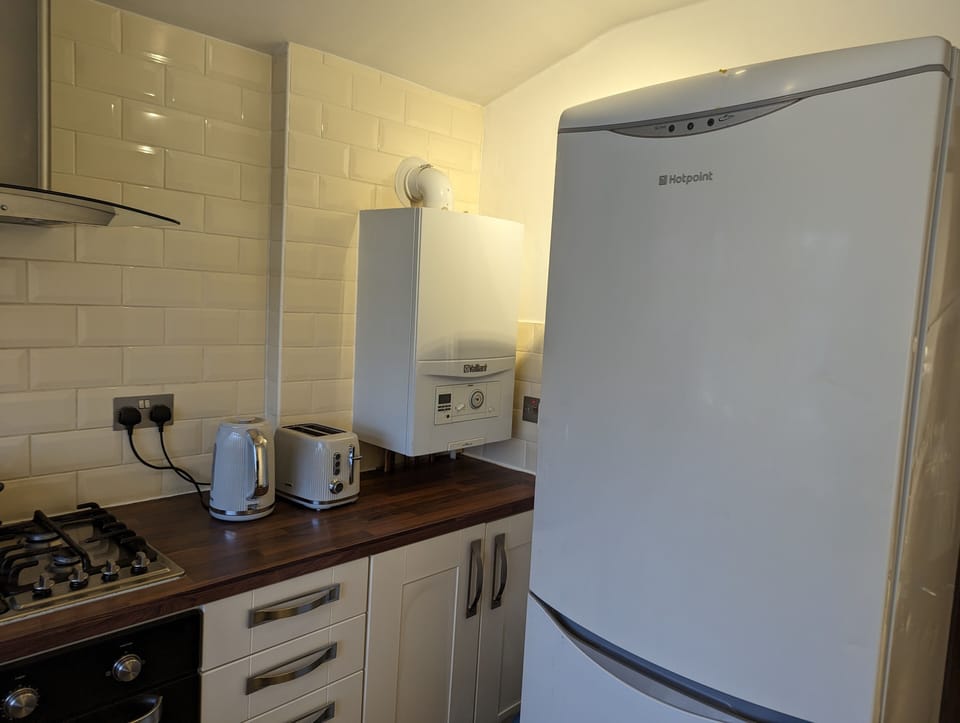 Fully fitted kitchen with gas oven and cooker, fridge-freezer, microwave, toaster, kettle, and washing machine.