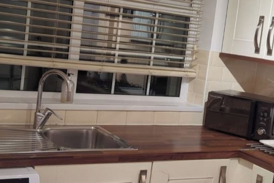 Fully fitted kitchen with gas oven and cooker, fridge-freezer, microwave, toaster, kettle, and washing machine.