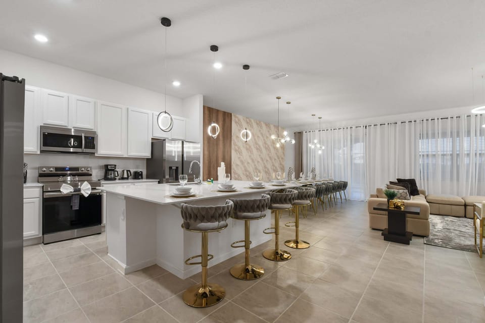 Modern chef’s kitchen with marble-style dining, luxe seating, and open living flow

