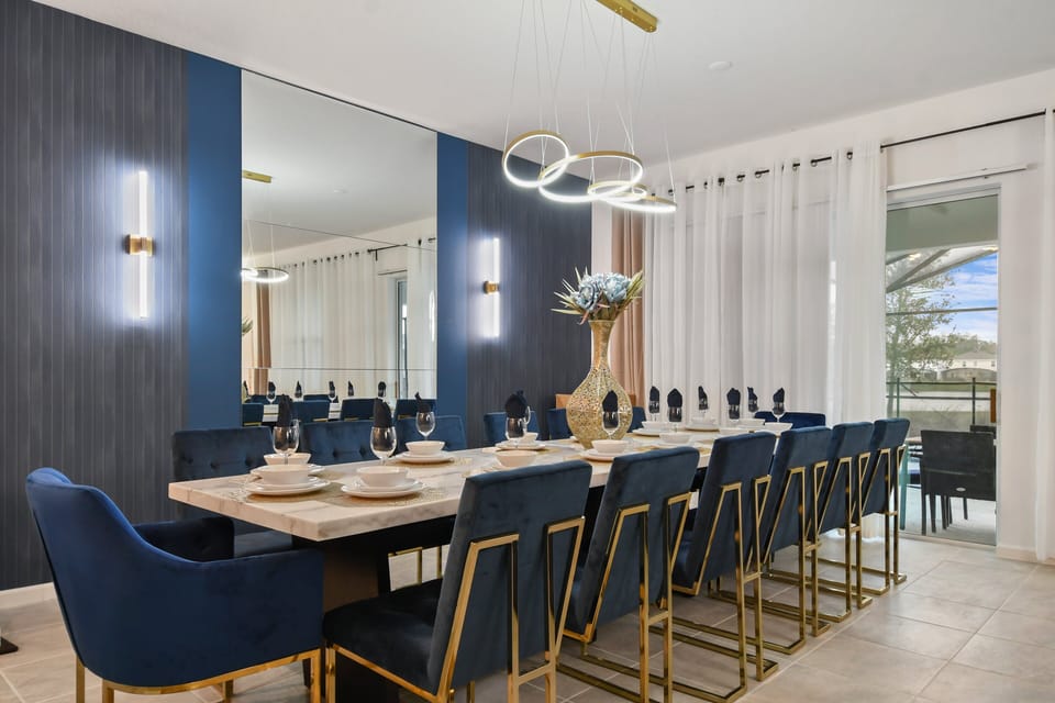 Elegant dining room with velvet chairs, gold accents, and mirror wall—dine in style!