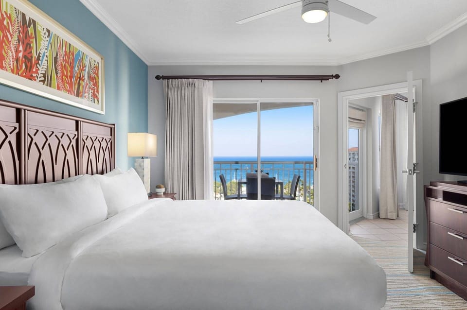 Primary Bedroom features a king bed, door to the private balcony, and an ensuite bathroom (ocean view).