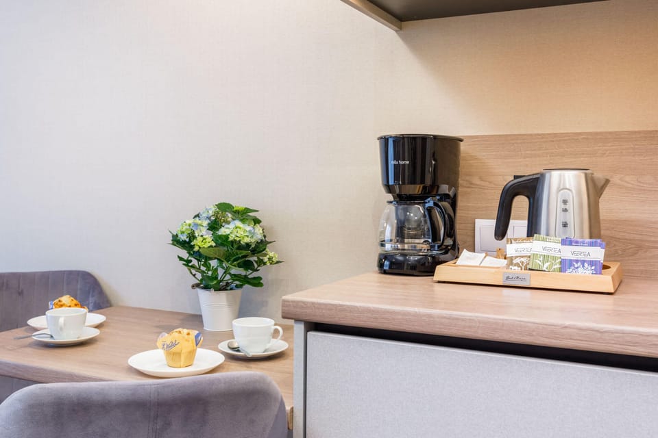 A close-up of a coffee machine and kettle, highlighting the apartment's amenities.
