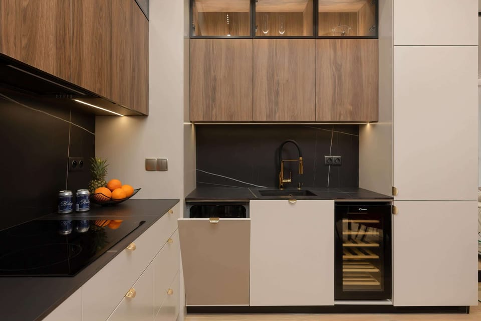 A close-up of the kitchen, featuring sleek appliances, wooden cabinets, and a modern backsplash.
