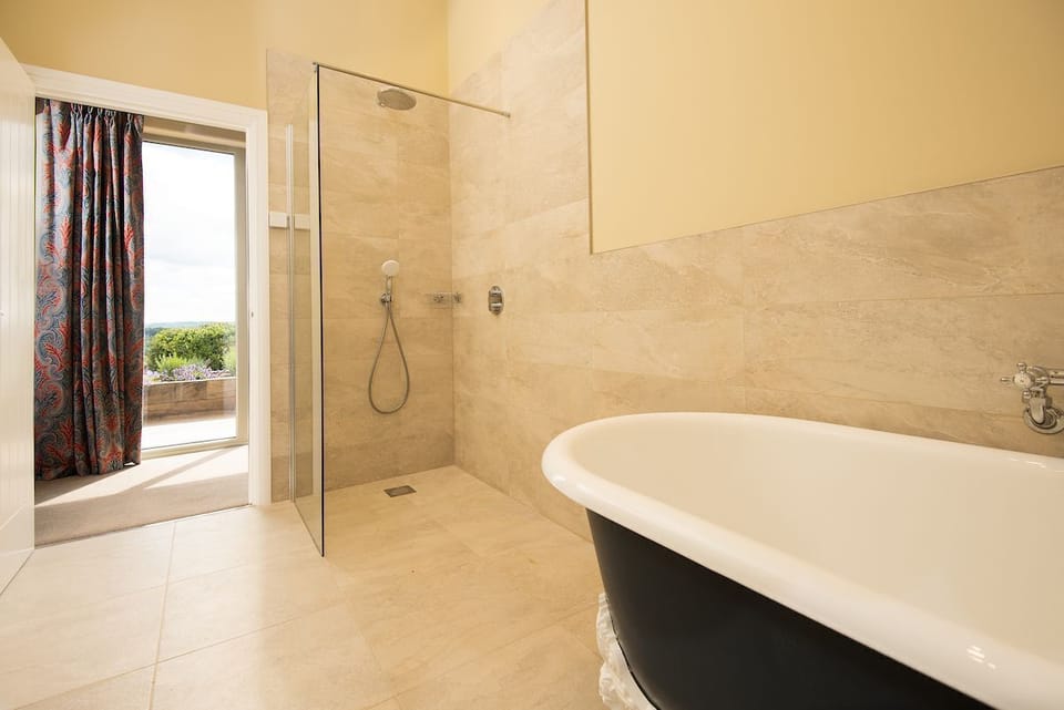 Shepherd's House - bedroom one en-suite walk-in wet room shower with separate roll top bath, heated towel rail, basin and WC