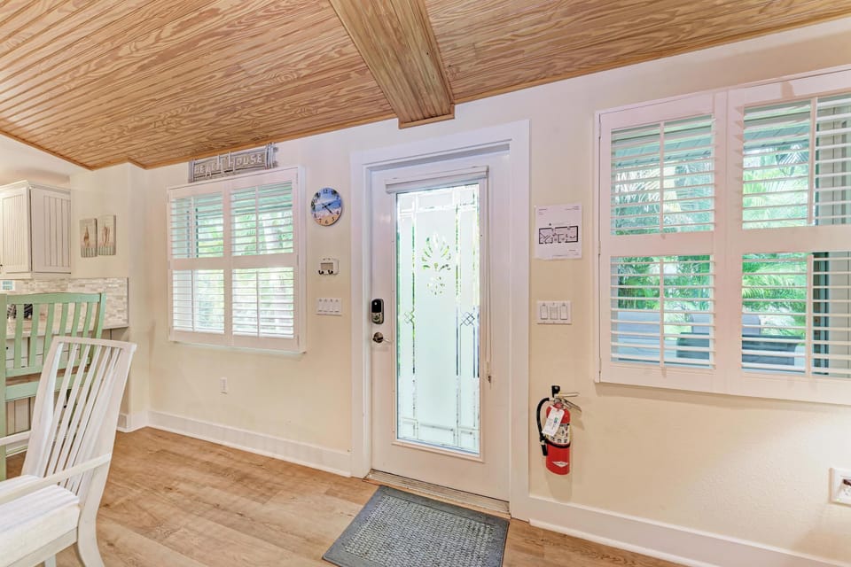 Step into your bright coastal retreat with stunning wood-beam ceilings and plantation shutters filtering natural light throughout this welcoming space.