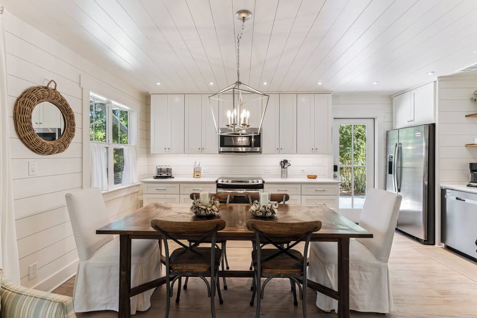Step into this bright farmhouse kitchen where you'll love cooking together at the spacious island, sharing meals at the rustic dining table under charming pendant lighting.