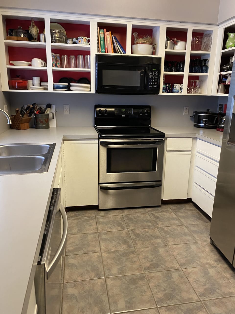 Fully equipped kitchen with fridge, dishwasher, microwave, pans, dishes, etc