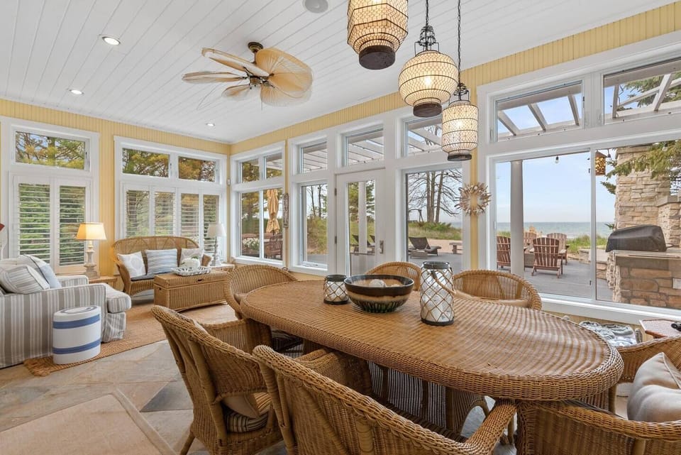 Airy three-season porch w/ high ceilings & expansive windows.