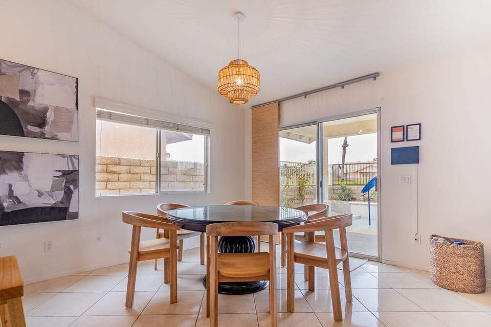 Dining table with wooden chairs. Patio door to the pool area