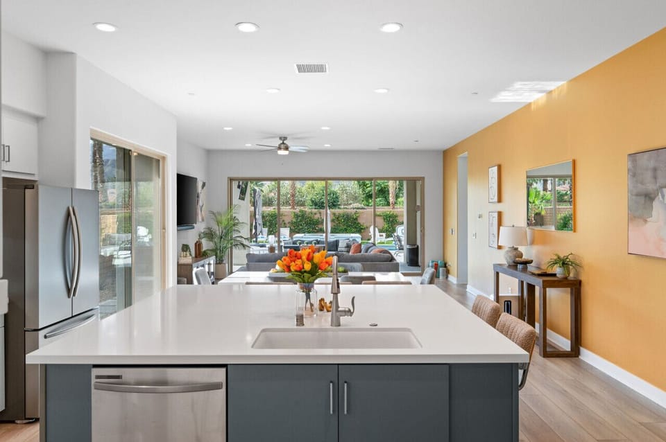 Spacious kitchen flows to the living area w/ backyard views through wide glass doors