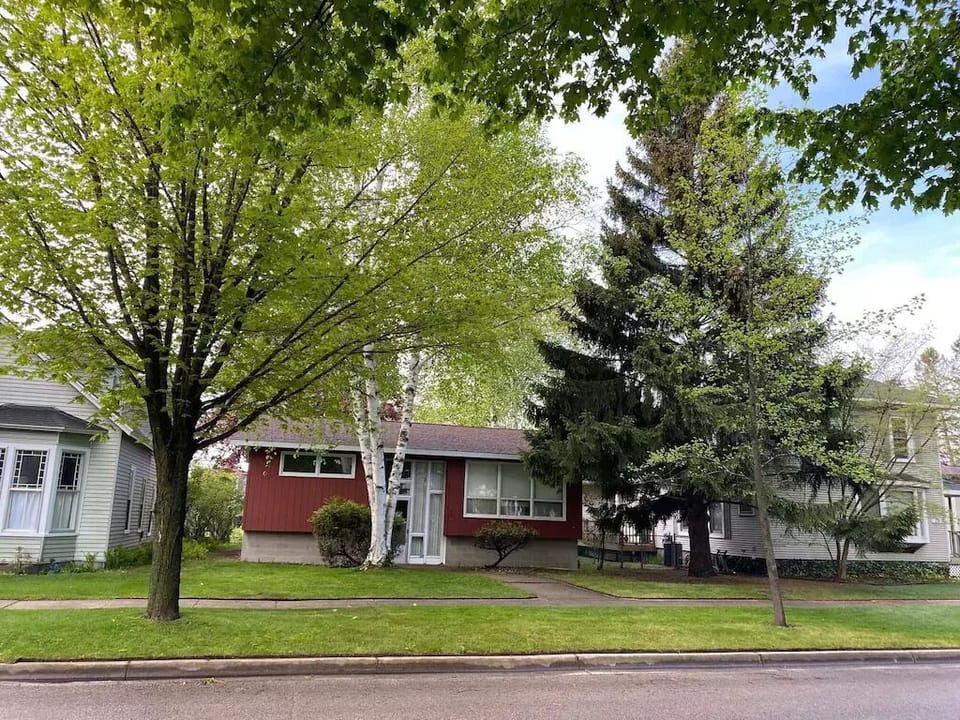 EXTERIOR:  The front of the house in summer.