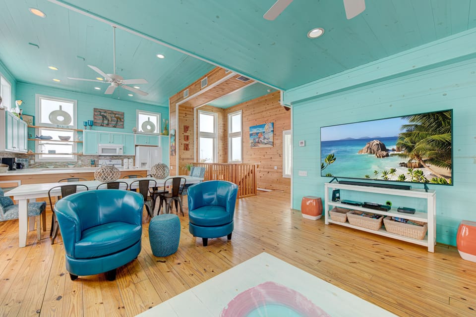 Unwind in your coastal-themed living space with turquoise accents, comfy seating, and entertainment center - perfect for relaxing after beach adventures.