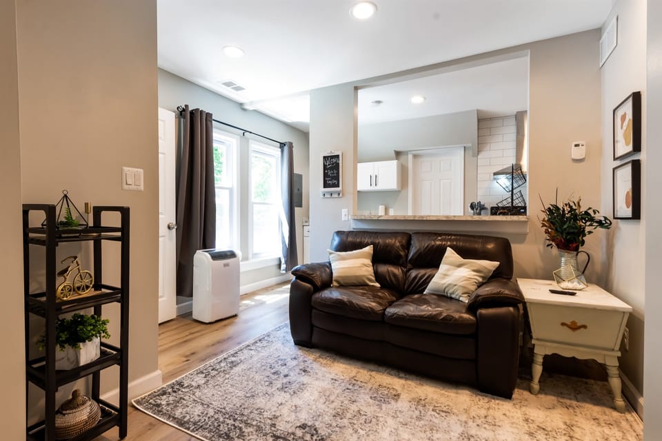 The comfortable couch and the rug make this living room the perfect spot to curl up with a warm blanket and a cup of coffee on a cold day.