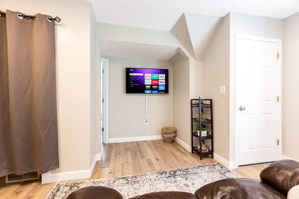 A living room with a flat screen TV, the perfect place to relax and be entertained.