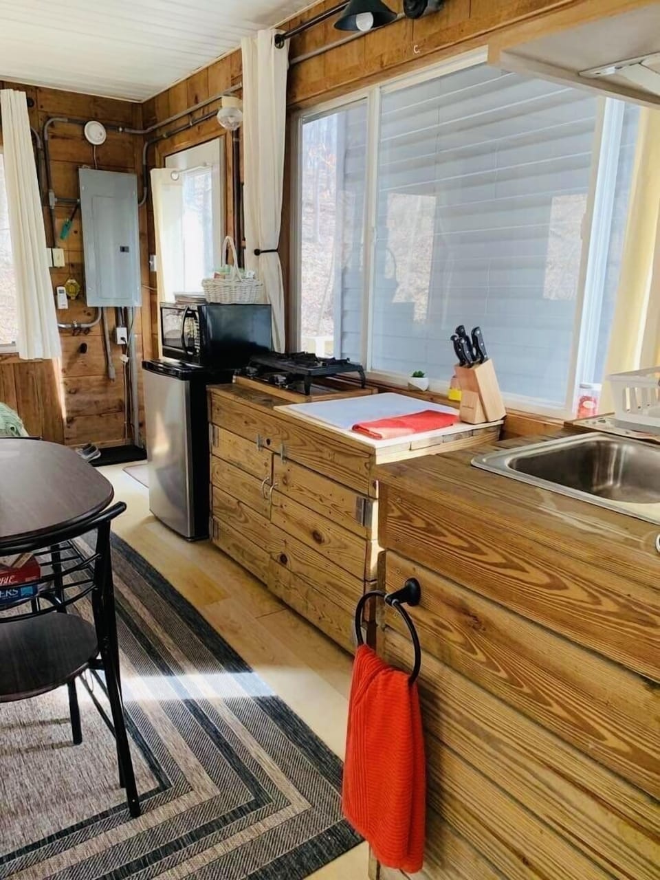 Kitchen with gas tabletop stove, fridge, microwave, coffee maker and utensils