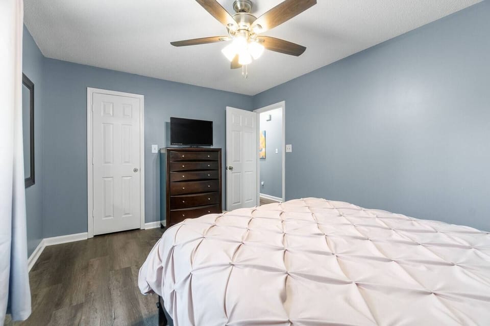 Enormous primary bedroom with walk-in closet offers plenty of storage, TV, high speed internet, alarm clock, nightstand, natural light, blinds and curtains, ceiling fan, queen sized bed with extra bedding central heating and air conditioning and more. 