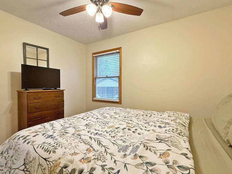 Queen bedroom with smart TV and shared bathroom