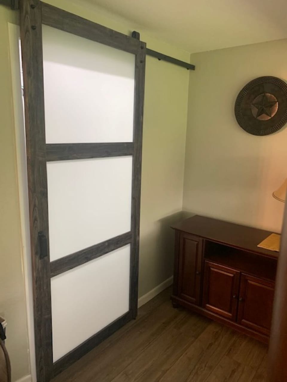 Barn door covers walk in closet in primary bedroom