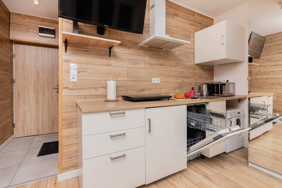 A well-equipped kitchen with wooden cabinetry, modern appliances, and a stylish backsplash.
