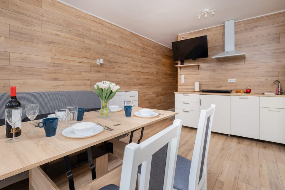 A view of the open kitchen and dining area, showcasing its functionality and natural wood tones.
