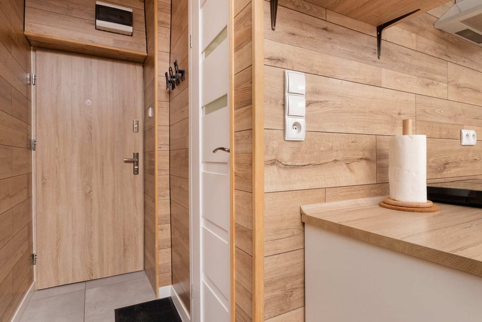 A close-up of a kitchen corner with practical storage and subtle wooden accents.
