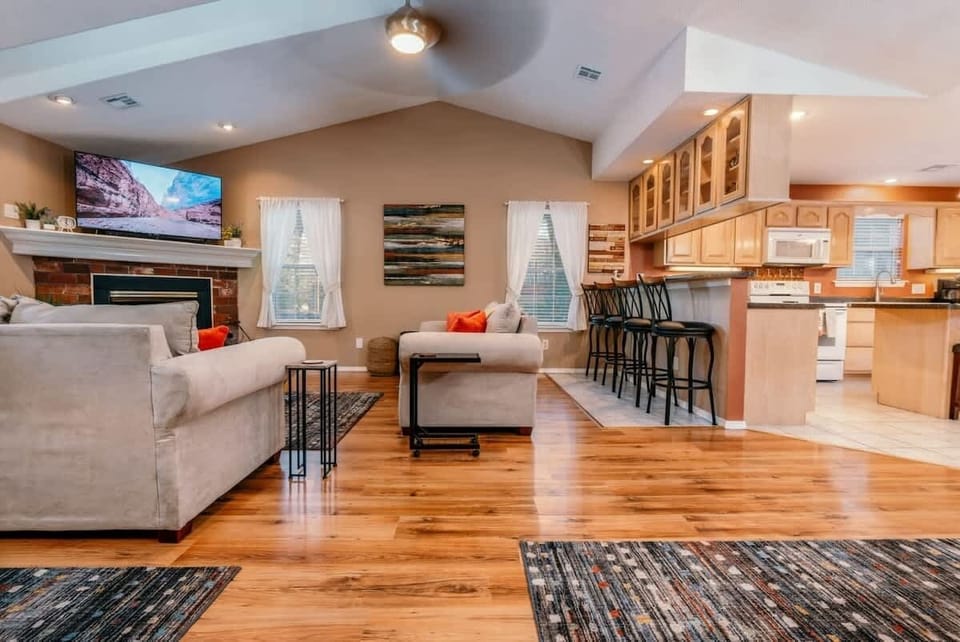 Open-concept living & dining area with rustic accents, comfy seating, & smart TV for relaxing evenings.