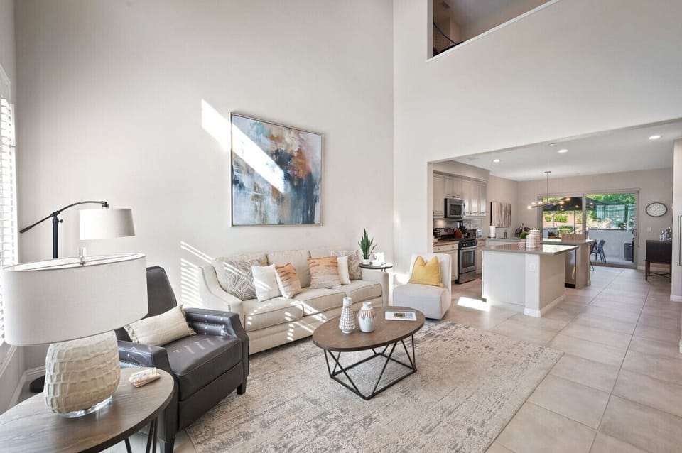 Inviting lounge w/ plush seating, soft tones & open flow into the main living space