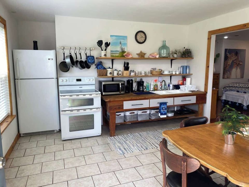 Kitchen with dishes utensils cookware coffee maker, toaster, range/refrigerator/freezer/ice maker, microwave. Large Dining Table & 6 Chairs.
Outdoor patio with natural gas grill, cooking tools, tables & chairs porch swings & fire pit. 