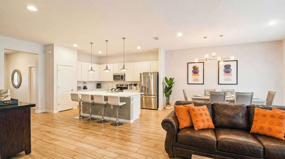 Fully equipped modern kitchen with island seating and open flow to dining area.
