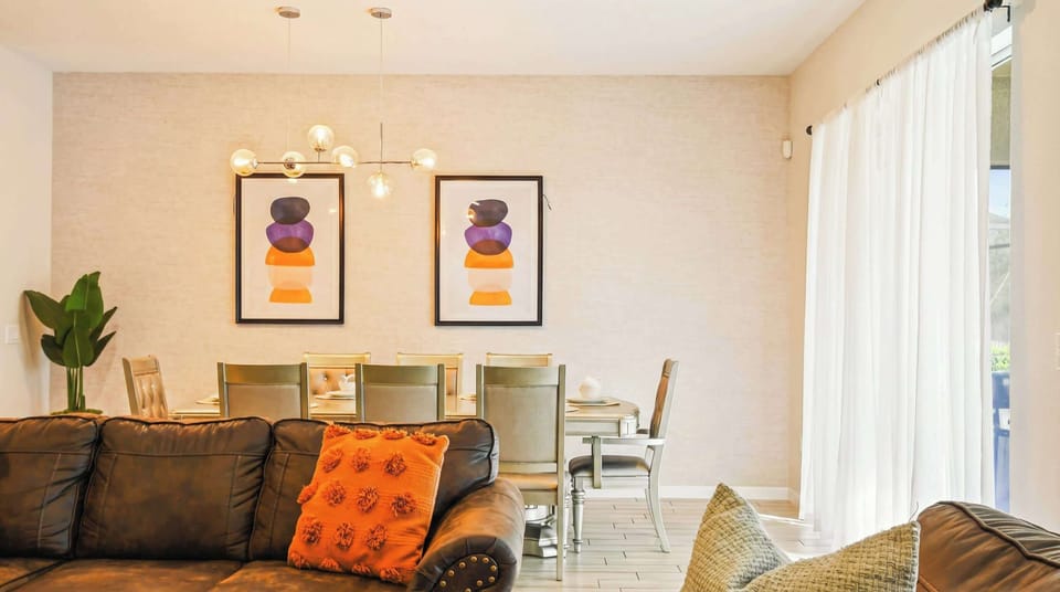 Elegant dining area with modern art, sleek lighting, and seating for eight.
