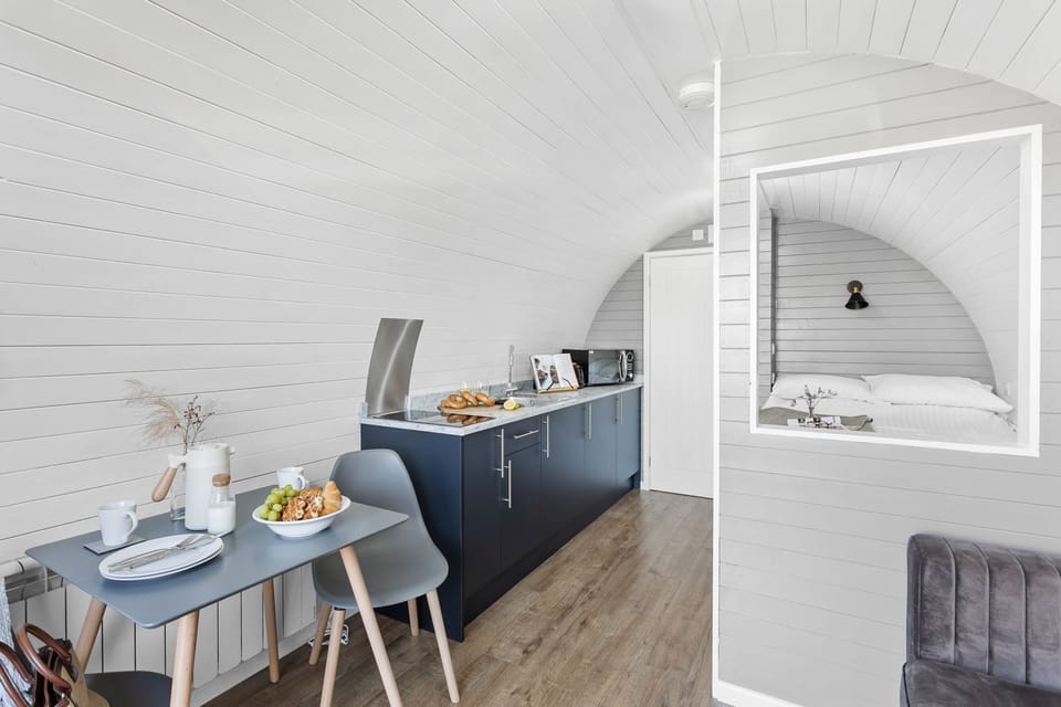 Dried flowers on dining table with microwave and toaster on counter - Windsor Glamping Pod