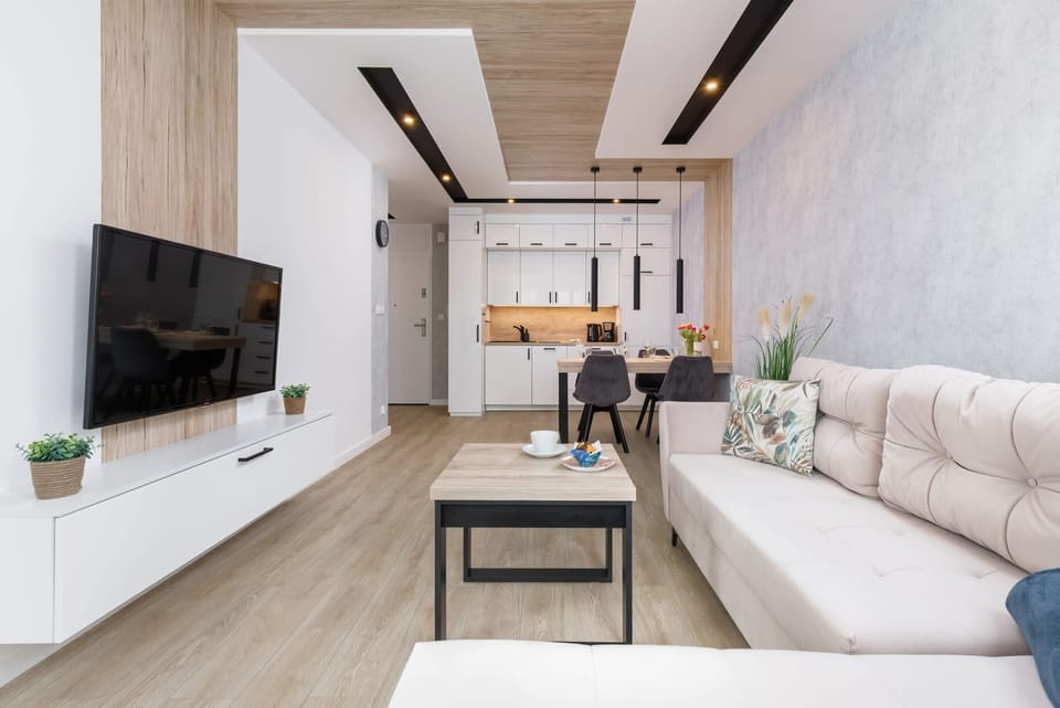 The main living room, designed with modern furniture and a large TV unit.
