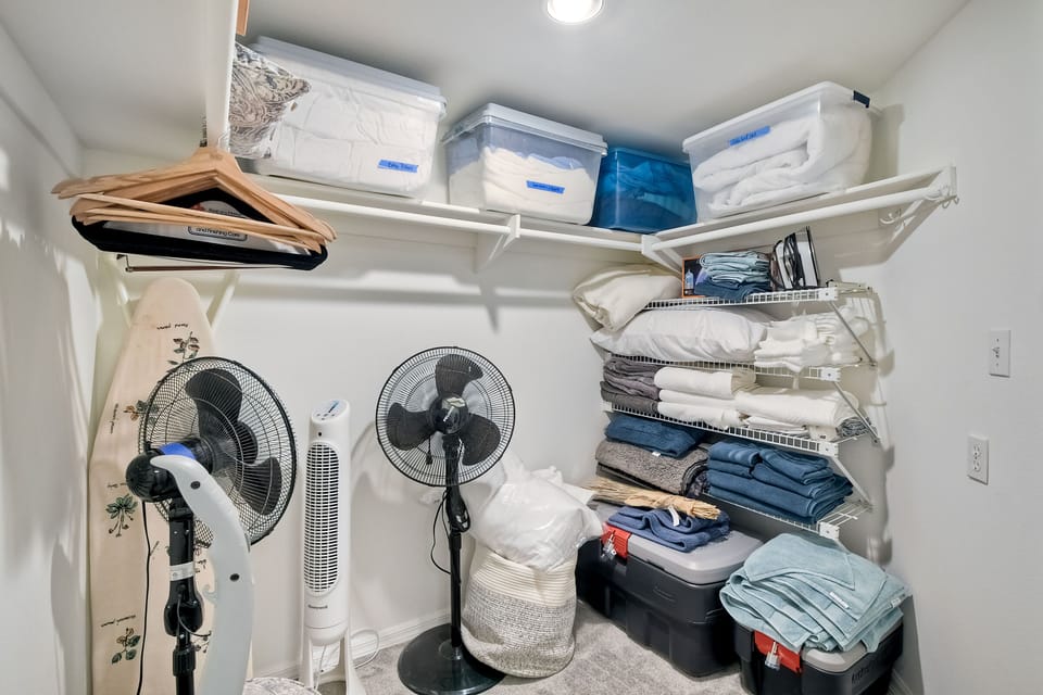 Walk-in closet in master with plenty of extra bedding and portable fans